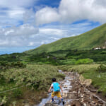 小川をトレッキングする子ども