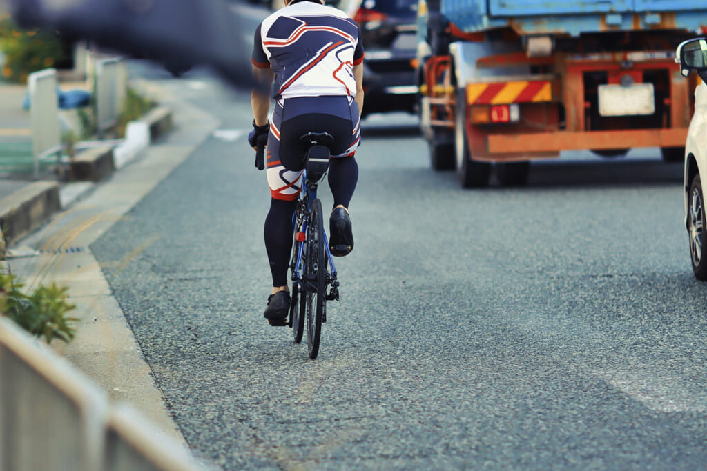 車道を自転車で走る男性