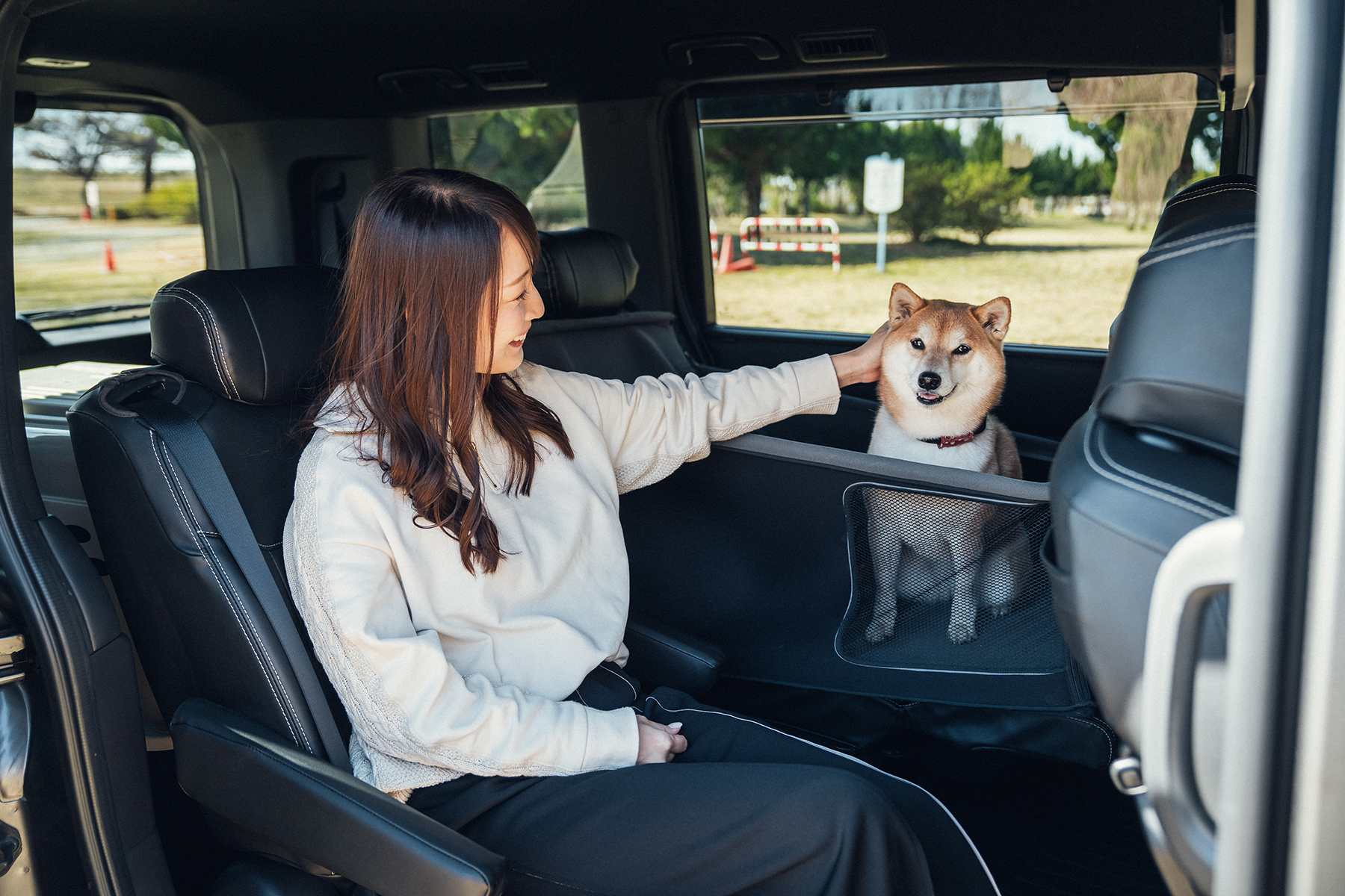 「ペットサークル」に入った柴犬とそれをあやす女子