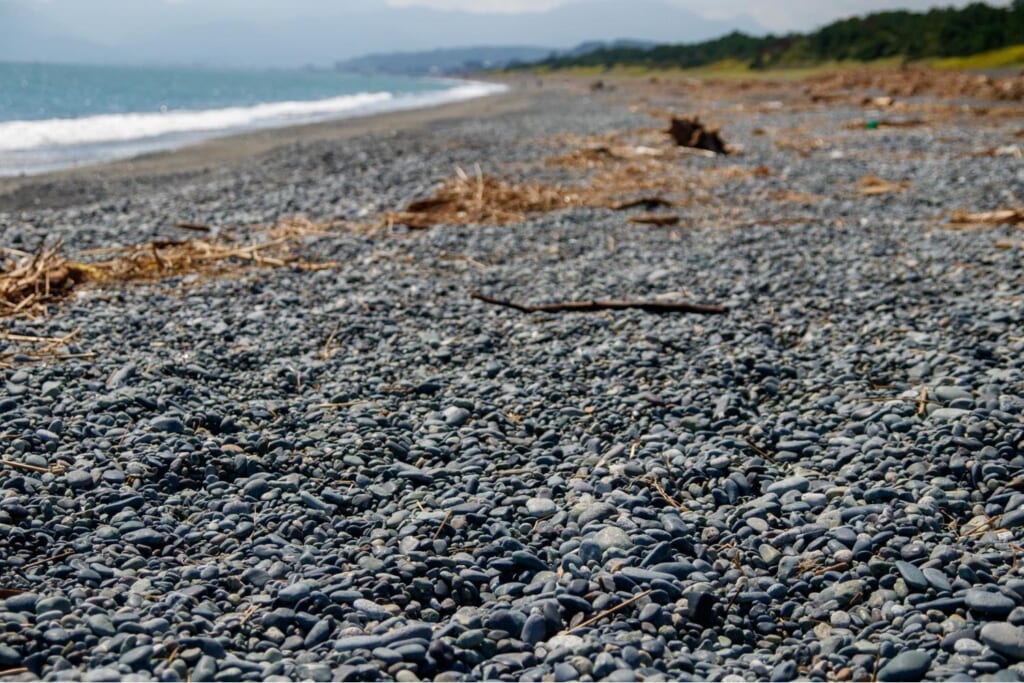 足に負担のかかる石が続く浜