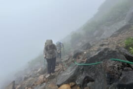 雨の中登る人