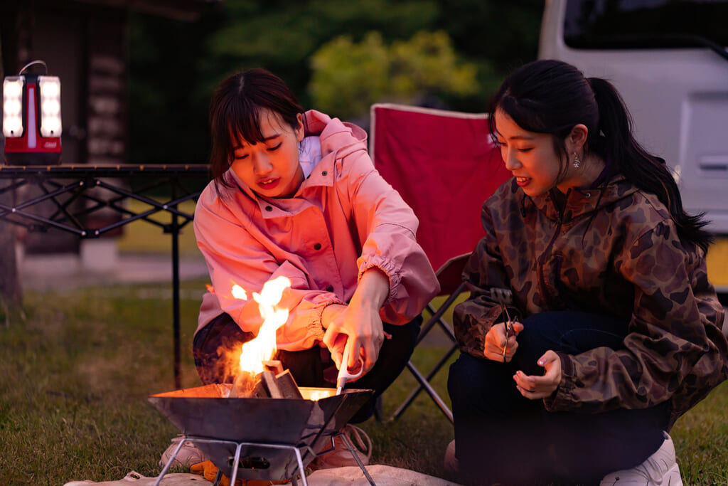 焚き火するキャンプ女子