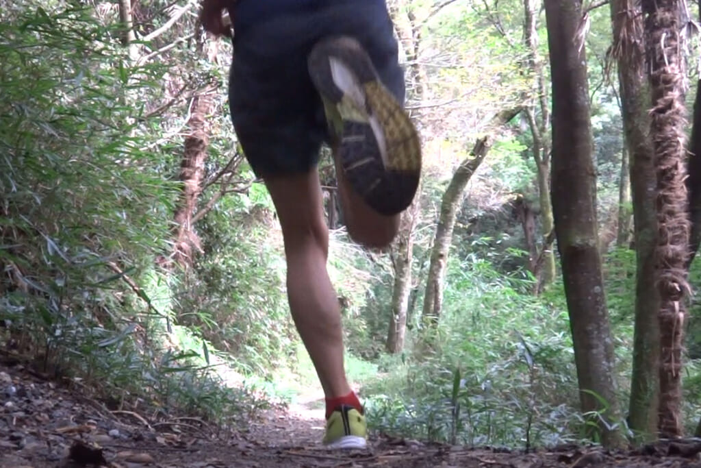 山道を駆け抜ける男性ランナー