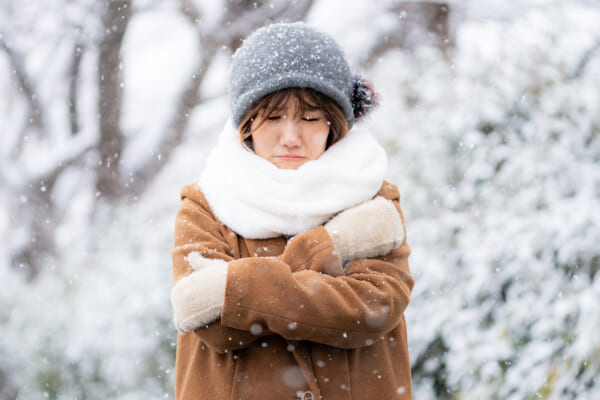 雪が降る中で寒がっている人